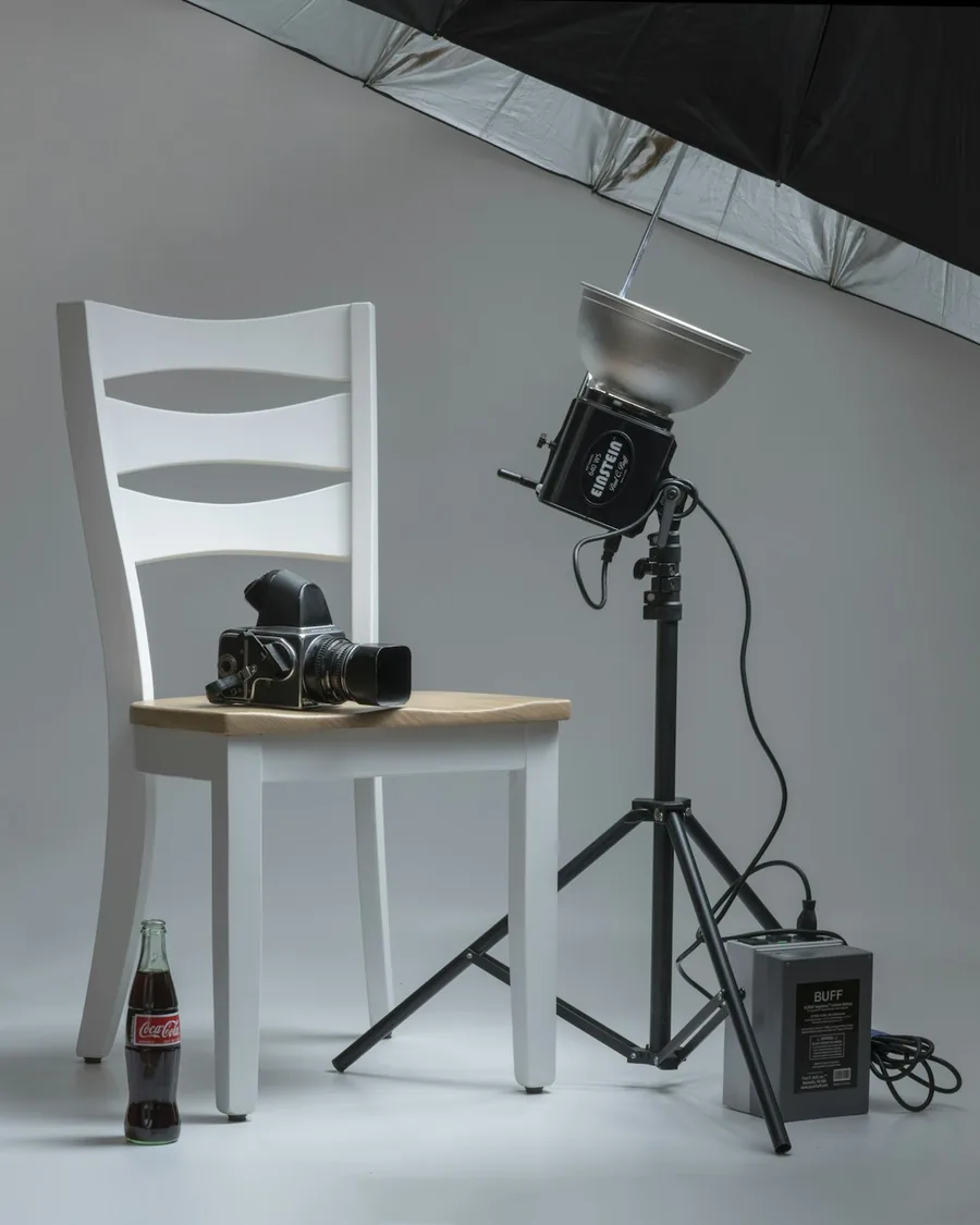 Studiový deštník a fotoaparát na stativu připravené k focení v ateliéru