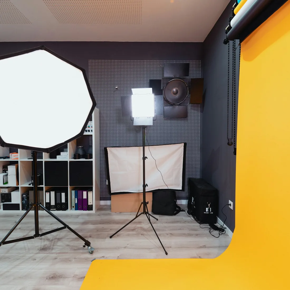 Fotografický ateliér s postaveným světlem na stativu a připraveným pozadím